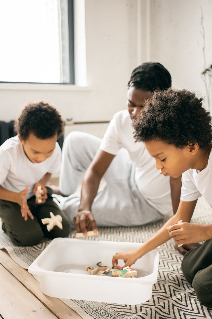 black father with sons putting wooden figures in box at home